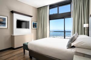 a hotel room with a bed and a large window at Premier Hotel Cape Town in Cape Town