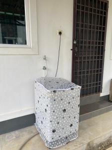uno sgabello a pois seduto di fronte a una porta di Ladiya Homestay Islamic 