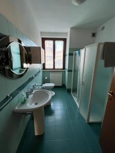 a bathroom with a sink and a toilet and a mirror at Casa Gianfranco in Gubbio