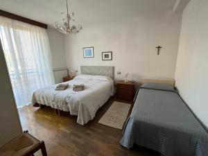 a bedroom with two beds and a cross on the wall at Casa Gianfranco in Gubbio