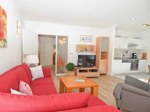 a living room with a red couch and a table at Villa am Park - Apt. 02 Düne in Ostseebad Sellin