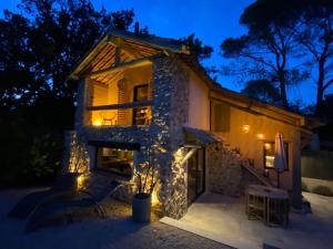 una casa de piedra con luces encendidas por la noche en PRIVATE ROOM & SPA avec Jacuzzi privatif en Lorgues