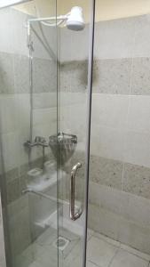 een douche met een glazen deur in de badkamer bij Lux Suites Kileleshwa Business Studio Apartment in Nairobi