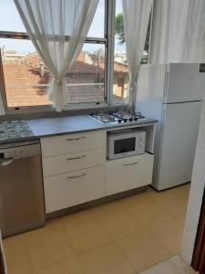 a kitchen with a stove and a refrigerator and a window at Angela Home in Rimini