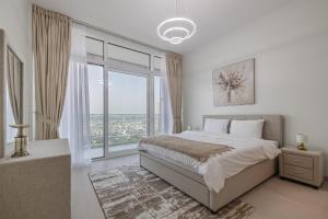 a bedroom with a bed and a large window at Close To Metro with Frame View in Dubai
