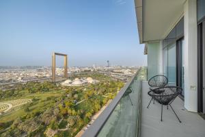 a balcony with two chairs and a view of a city at Close To Metro with Frame View in Dubai