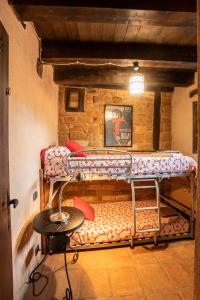 a room with a bunk bed with a table in it at Sierra de Gata EL CORRAL DE LA HIGUERA in Torre de Don Miguel
