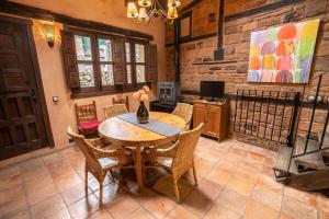 a dining room with a wooden table and chairs at Sierra de Gata EL CORRAL DE LA HIGUERA in Torre de Don Miguel
