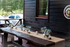 uma mesa de madeira com vasos de plantas num alpendre em Auksinio elnio slėnis em Rukliai