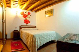 a bedroom with a bed and a vase of flowers on the wall at Casa Rural Lucía es una casa rural amplia con patio ideal para familias in Cabezas Bajas