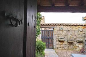 eine Tür zu einem Haus mit einer Steinmauer in der Unterkunft Casa Rural Lucía es una casa rural amplia con patio ideal para familias in Cabezas Bajas