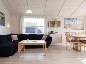 a living room with a black couch and a table at 6 person holiday home in GROEMITZ in Grömitz