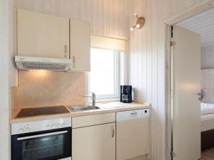 cocina con fregadero, fogones y ventana en 6 person holiday home in GROEMITZ en Grömitz