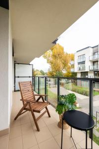 a balcony with a chair and a table at Komfortowy apartament z parkingiem in Wrocław