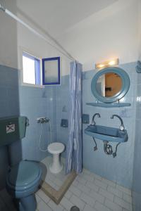 a blue bathroom with a toilet and a sink at DARZENTA ATHINA APARTMENTS Perivolos in Perivolos