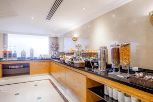 a kitchen with a counter with some food at Golden Sands Suites in Dubai