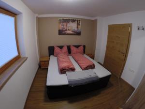 ein Schlafzimmer mit einem Bett mit vier Kissen darauf in der Unterkunft Großzügiges Apartment Georg Mayrhofen Barrierefrei in Hollenzen
