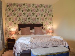um quarto com uma cama com papel de parede floral em The Ramparts em Montgomery