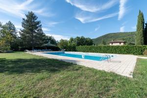 een zwembad in een tuin met een huis bij Casale Falco Grande in Chiusi della Verna