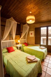 1 dormitorio con 2 camas y lámpara de araña en Sierra de Gata EL CORRAL DE LA HIGUERA, en Torre de Don Miguel