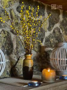 利勒哈默爾的住宿－Large Cottage 2 Baths and Sauna in Sjusjøen，黄色花瓶和桌子上的蜡烛