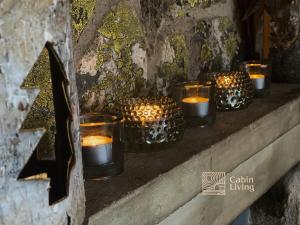 una fila de velas sentadas en un estante de piedra en Large Cottage 2 Baths and Sauna in Sjusjøen, en Lillehammer