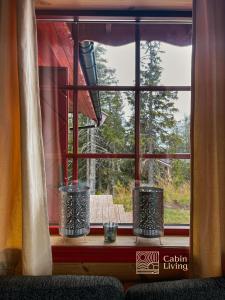 una ventana con tres velas sentadas en un alféizar de la ventana en Large Cottage 2 Baths and Sauna in Sjusjøen, en Lillehammer