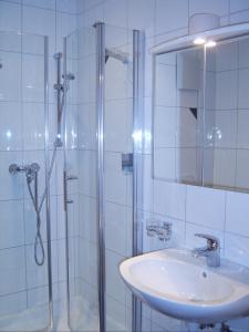 a bathroom with a sink and a shower with a mirror at Hotel Bergerhof in Bartholomäberg