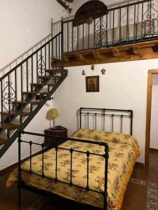 a bedroom with a bed next to a staircase at Tía Clotilde es una casa grande ideal para familias y grupos de amigos in Cabezas Bajas