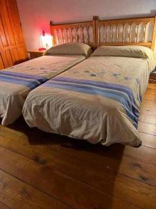 two beds sitting next to each other in a bedroom at Tía Clotilde es una casa grande ideal para familias y grupos de amigos in Cabezas Bajas