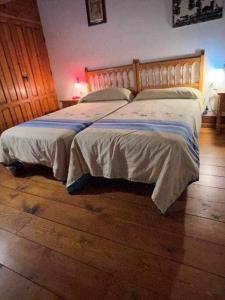 a bedroom with a bed and a wooden floor at Tía Clotilde es una casa grande ideal para familias y grupos de amigos in Cabezas Bajas