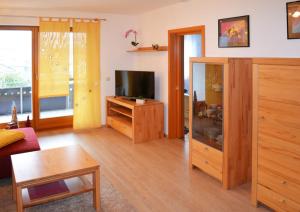 a living room with a television and a wooden floor at Ferienwohnung Nebenan in Ebern
