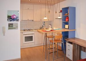 uma cozinha com armários brancos e uma ilha azul com bancos em Ferienwohnung Nebenan em Ebern