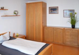 a bedroom with a bed and a wooden cabinet at Ferienwohnung Nebenan in Ebern
