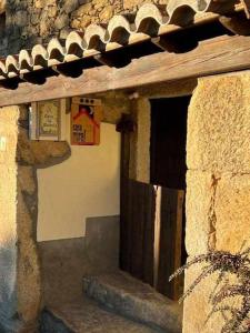 um edifício com uma porta de madeira e uma janela em Casa Tía Modesta es una cálida y acogedora casa rural em Cabezas Bajas