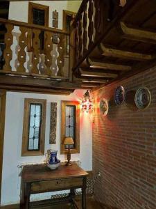 um quarto com uma mesa e uma parede de tijolos em Casa Tía Modesta es una cálida y acogedora casa rural em Cabezas Bajas