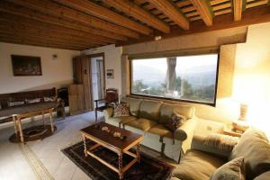 ein Wohnzimmer mit einem Sofa und einem großen Fenster in der Unterkunft Apartamento Rural El Labrador es un cómodo y acogedor apartamento in Cabezas Bajas