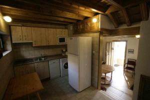 a kitchen with a white refrigerator and a table at Apartamento Rural El Labrador es un cómodo y acogedor apartamento in Cabezas Bajas