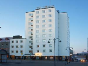 a white building with a sign on top of it at Hotell Högland in Nässjö