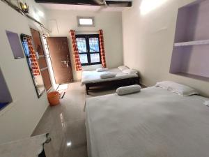 a room with two beds in a room with a window at Sunrise Lodge in Varanasi