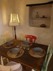 una mesa de madera con platos y gafas y una lámpara en Ca l'Agnès, en Montseny