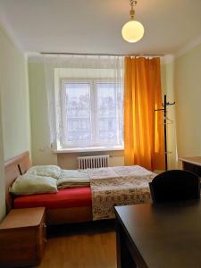 a bedroom with a bed in front of a window at Hostel Omega in Rzeszów