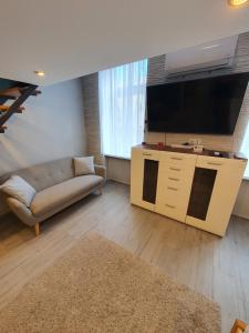 a living room with a couch and a large television at Belvárosi Exkluzív Loft in Debrecen