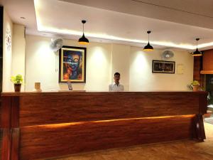 Un uomo in piedi dietro il bar di un ristorante di The Sarai, Hotel a Jaipur