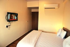 a hotel room with a bed and a tv on the wall at The Sarai, Hotel in Jaipur