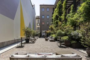 a courtyard with couches and tables and plants at Savona 18 Suites in Milan