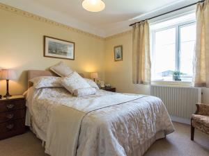 a bedroom with a bed and a window at Bucklawren Farm in Looe