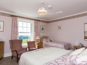 a bedroom with two beds and a window at Bucklawren Farm in Looe