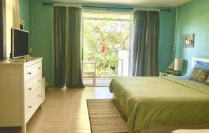 een slaapkamer met een bed, een televisie en een raam bij Chalianglom Resort Kohlarn in Ko Larn