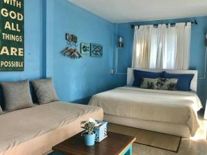 2 camas en una habitación con paredes azules en Chalianglom Resort Kohlarn en Ko Larn